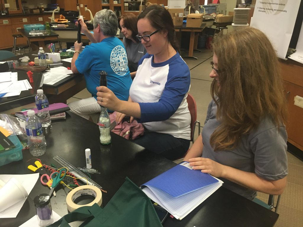 Teachers peforming an experiment with Coke bottles