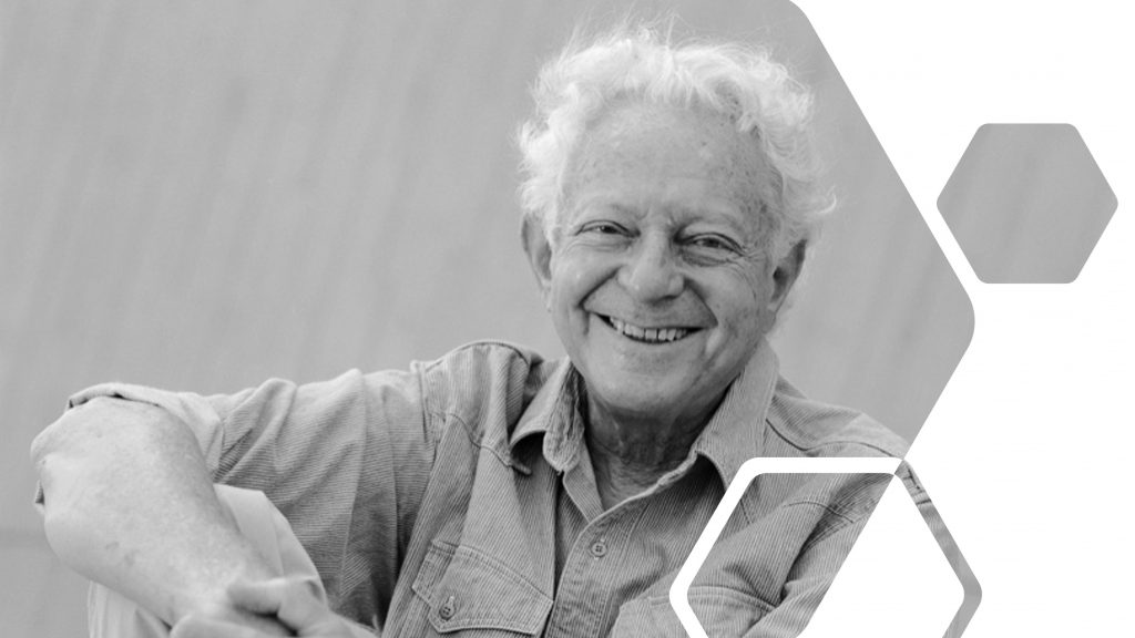 A black and white photo of Leon Lederman smiling. 