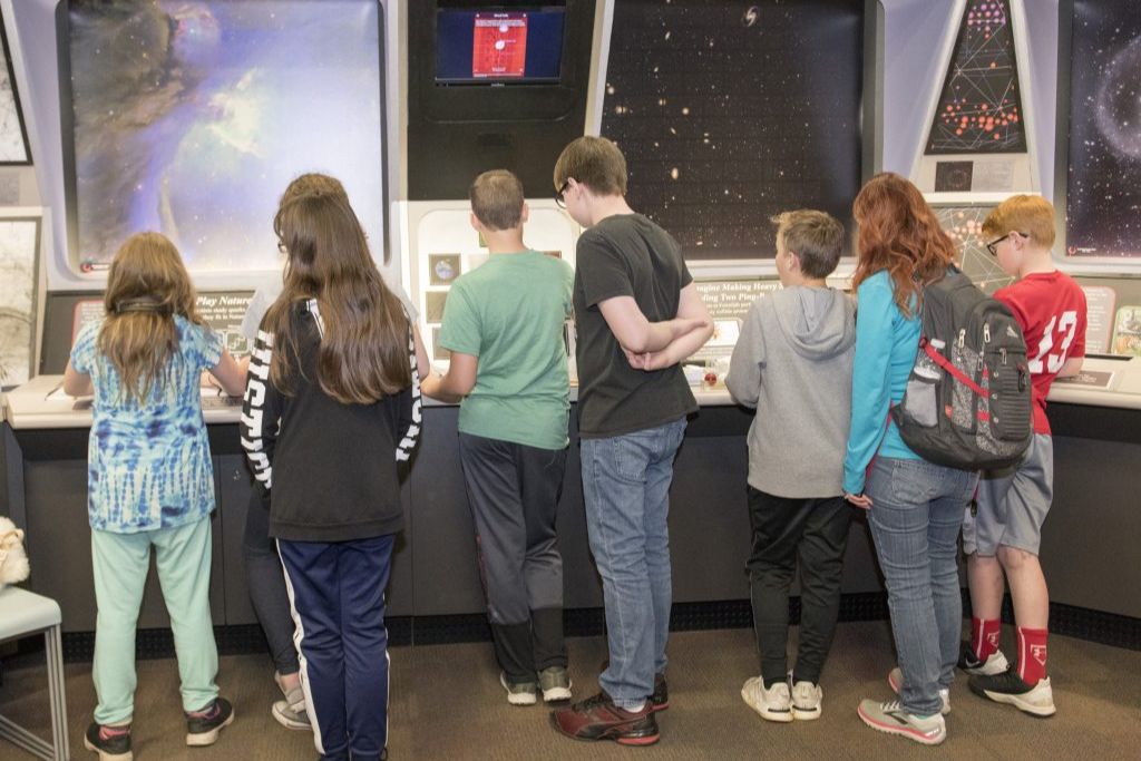 A group of students reading exhibits in the Ideas Room. 